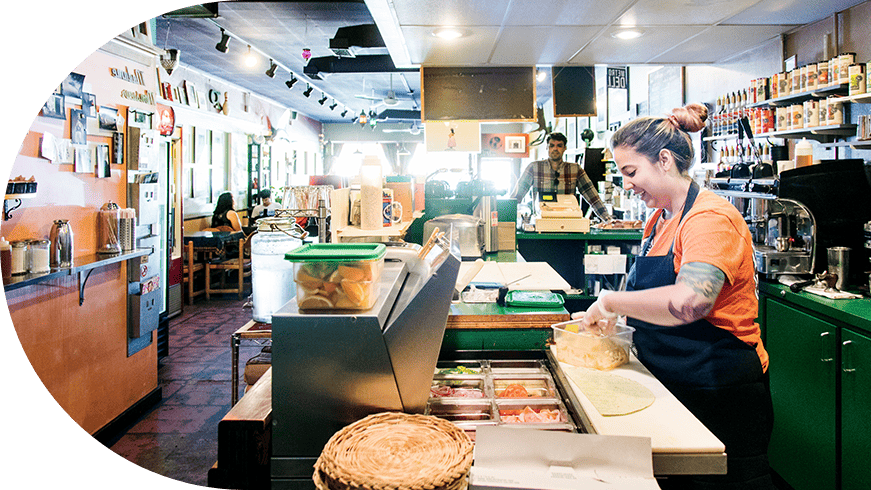 Service worker assembling a sandwich in a shop